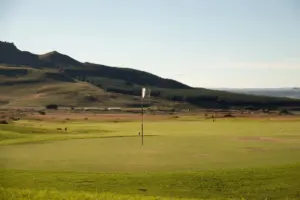 Golf course green with a flag at sunrise